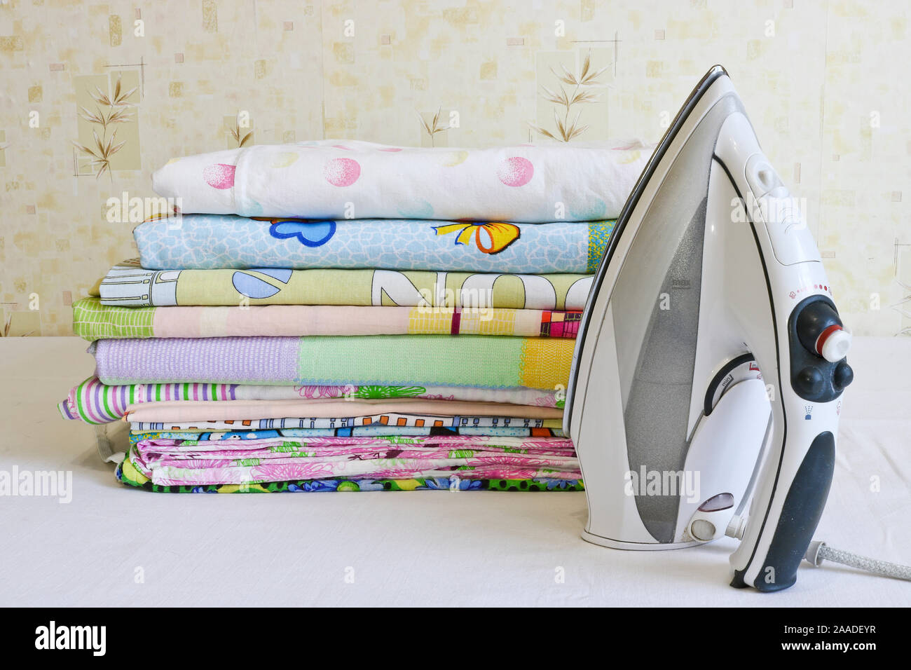 Modern iron and stack of ironed linen. Household chores Stock Photo Alamy