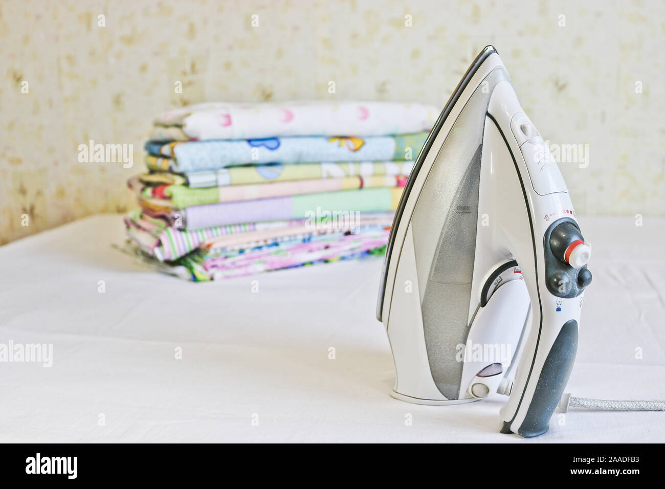 Modern iron and stack of ironed linen. Household chores Stock Photo Alamy