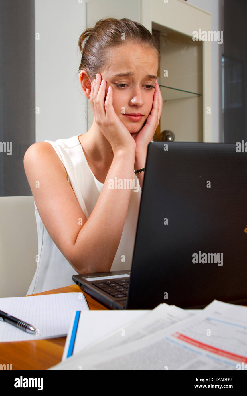 Zwanzigjährige sitzt enttäuscht vor laptop (mr) Stock Photo