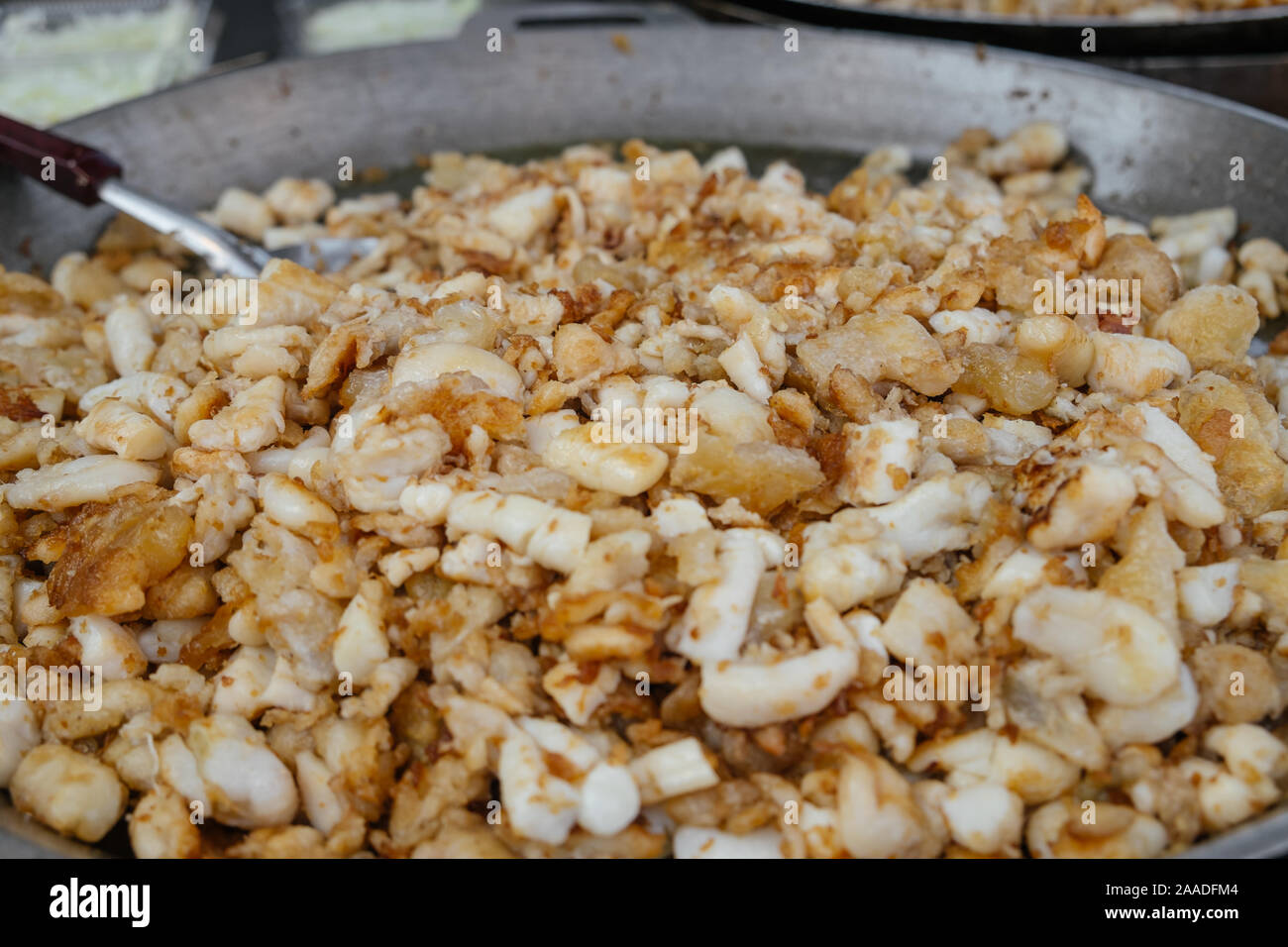 Freshly cooked stir fried squid eggs on flat pan for sale in a local street food fresh market in Bangkok, Thailand. Stock Photo