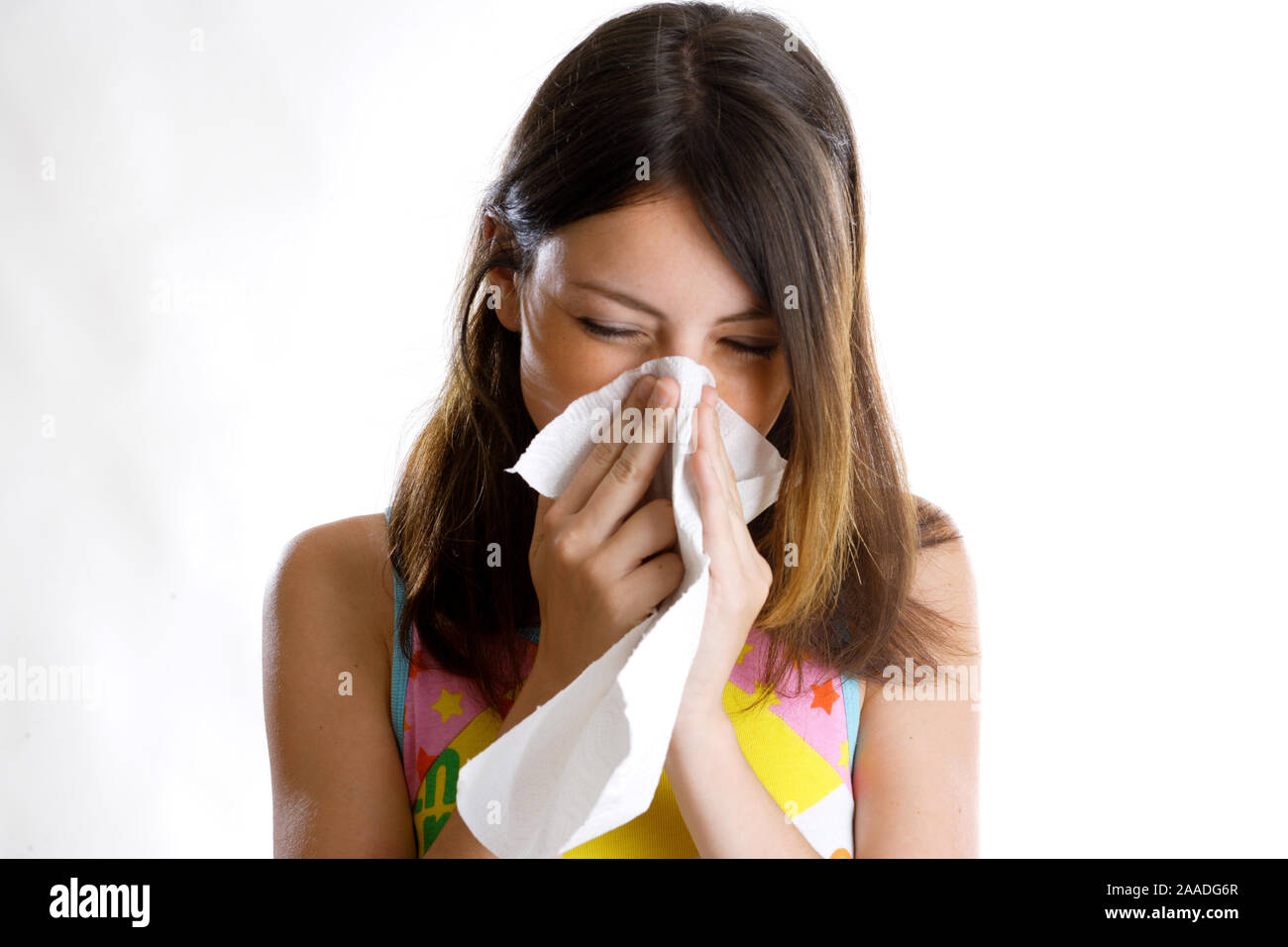 Junge Frau ist erkaeltet und putzt sich die Nase Stock Photo