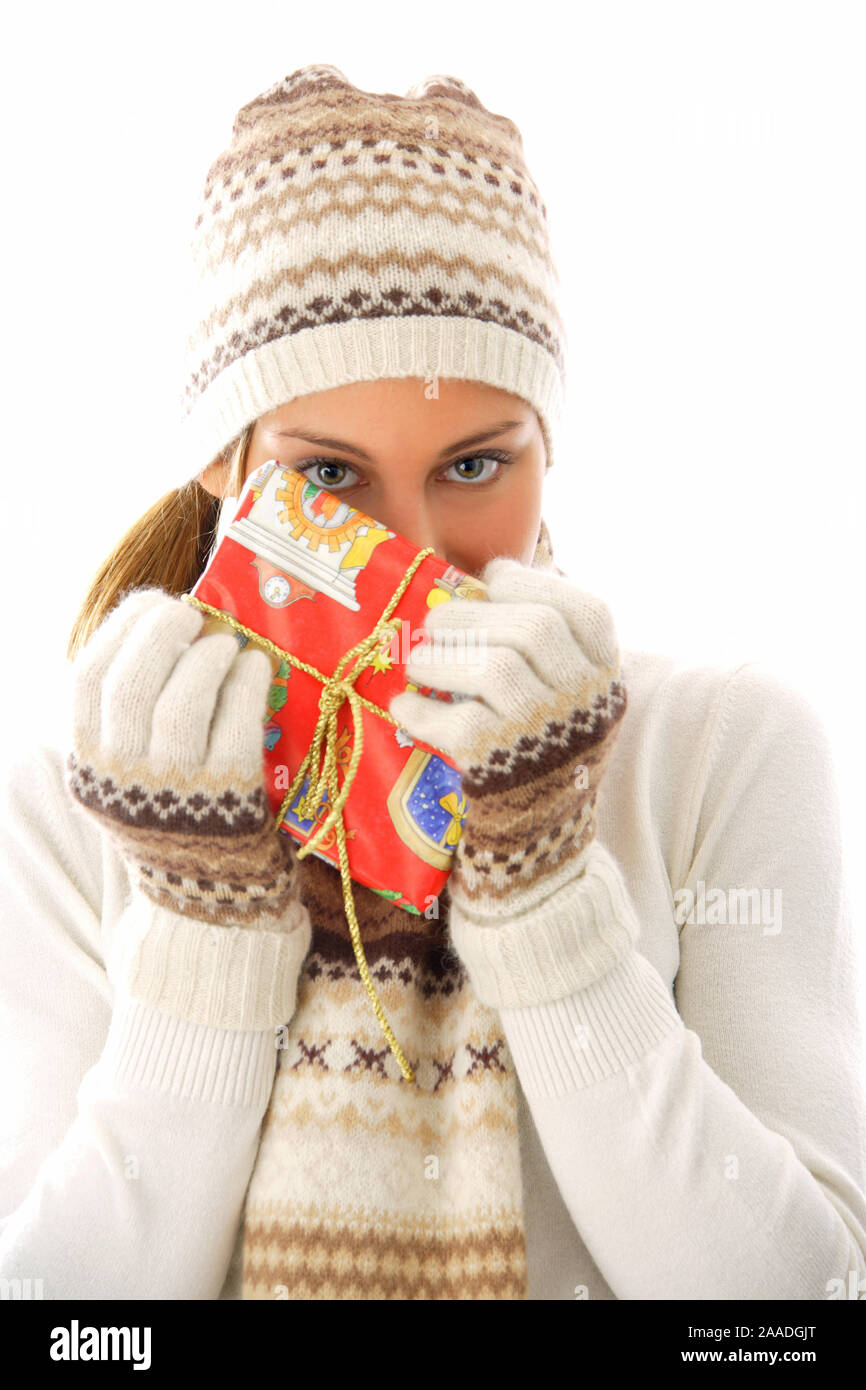 Junge Frau in Pudelmuetze und Schal mit Weihnachtsgeschenk Stock Photo