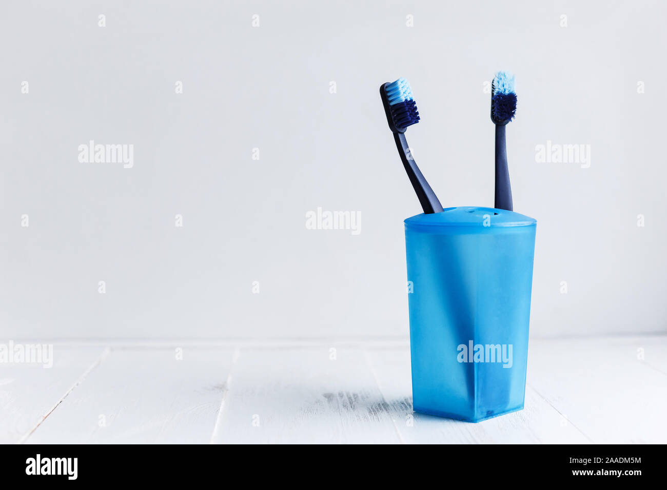 New and used blue color toothbrush in cup on white Stock Photo Alamy