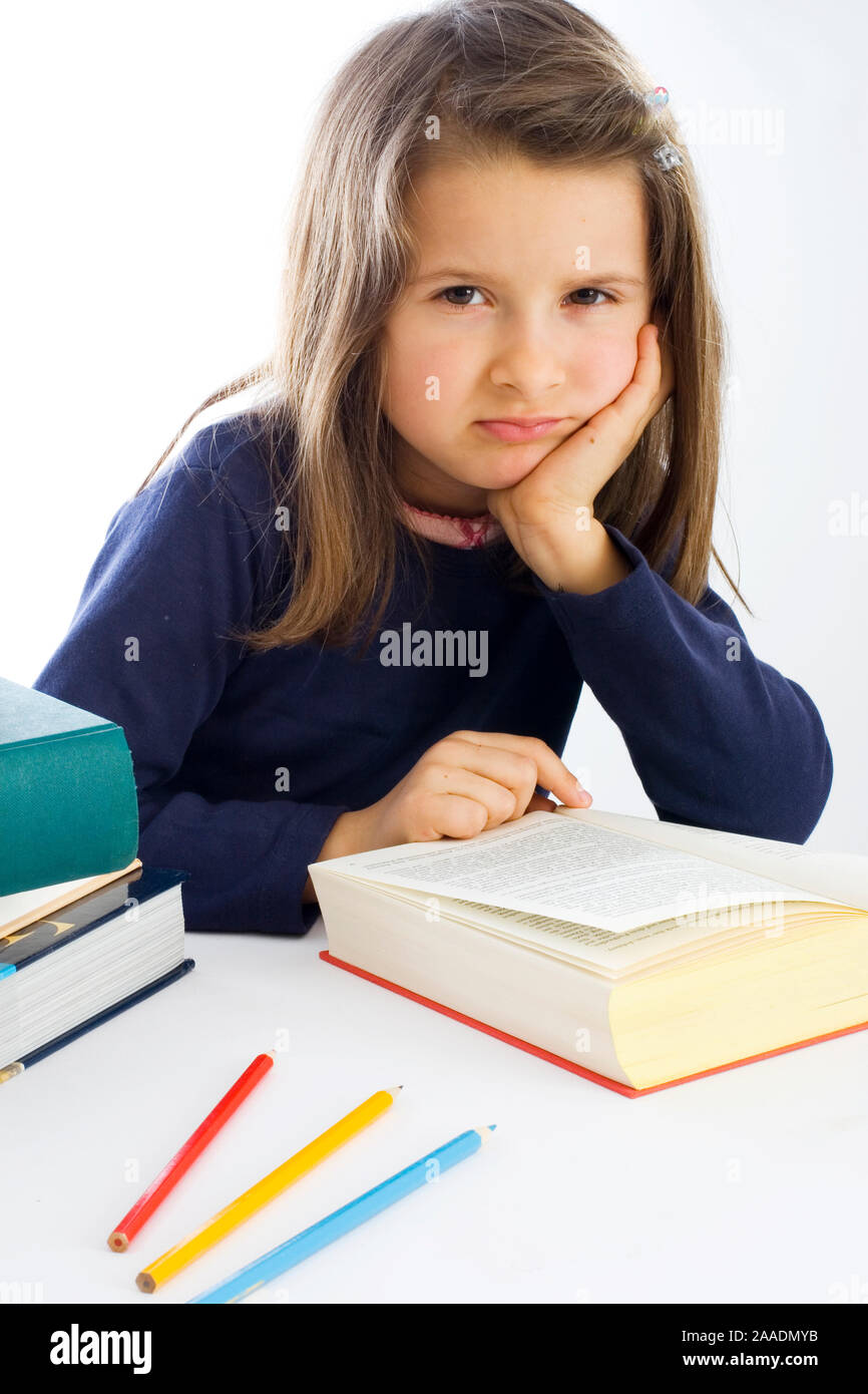 sechsjähriges Mädchen sitzt lustlos vor einem Buch (mr) Stock Photo