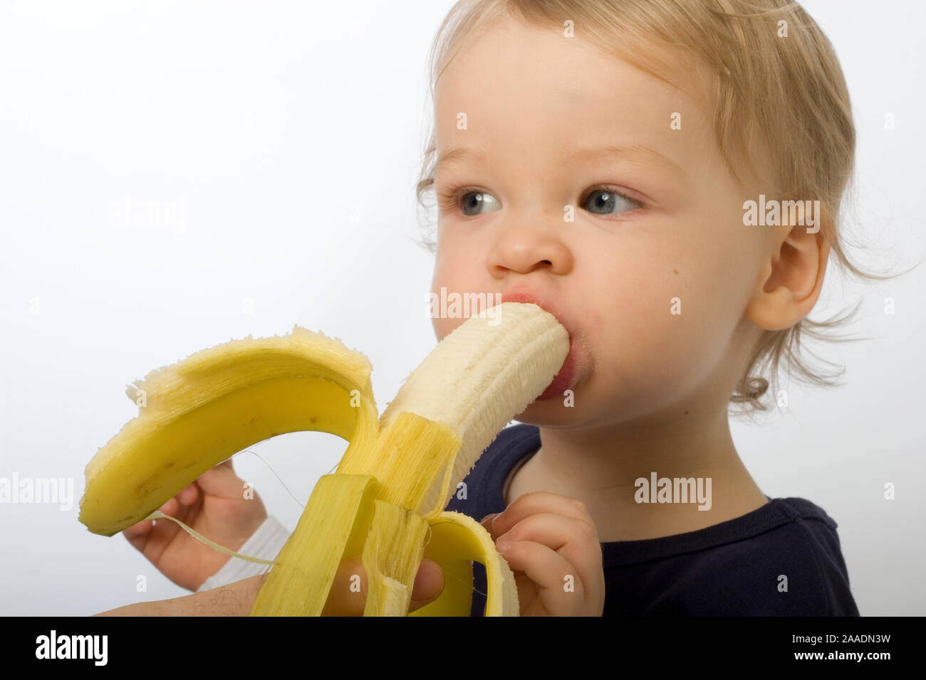 Kleinkind isst Banane (mr) Stock Photo