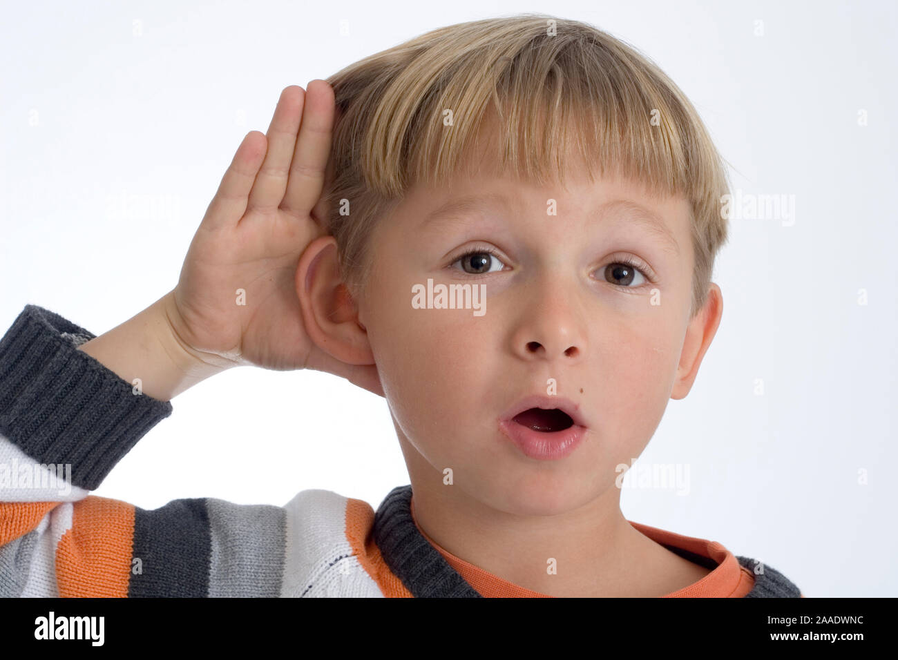 sechsjähriger Junge hält Hand an das Ohr (modell released) Stock Photo