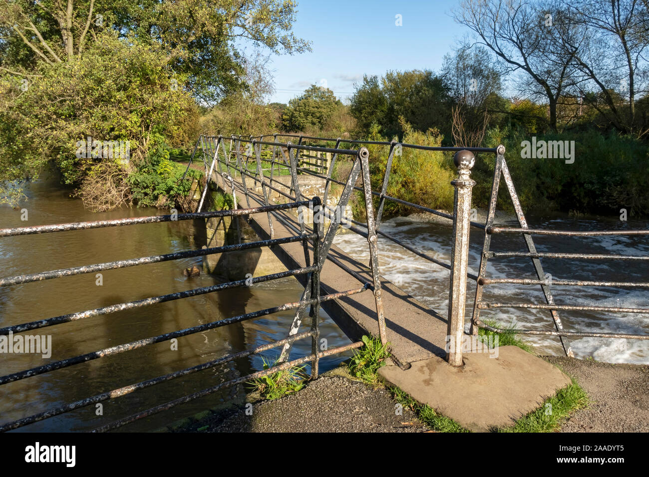 Narrow footbridge over the old sluice gates of Thirsk mill at Cod Beck Thirsk North Yorkshire England UK United Kingdom GB Great Britain Stock Photo