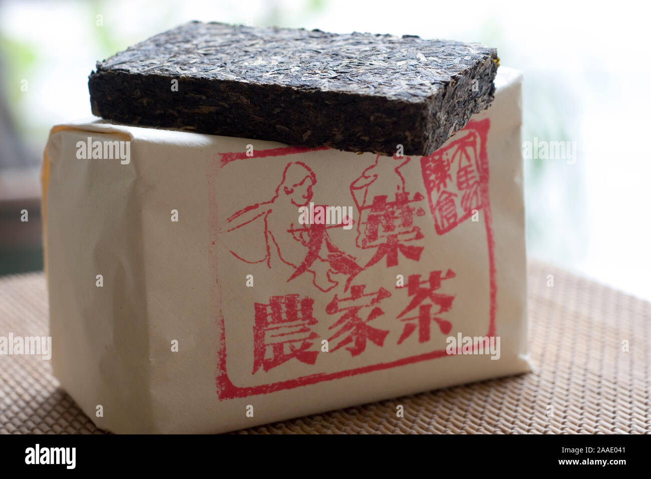 chinesischer Tee (der gepresste Riegel oben auf ist Green pur tea, in der Verpackung darunter ist Black pur tea) Stock Photo