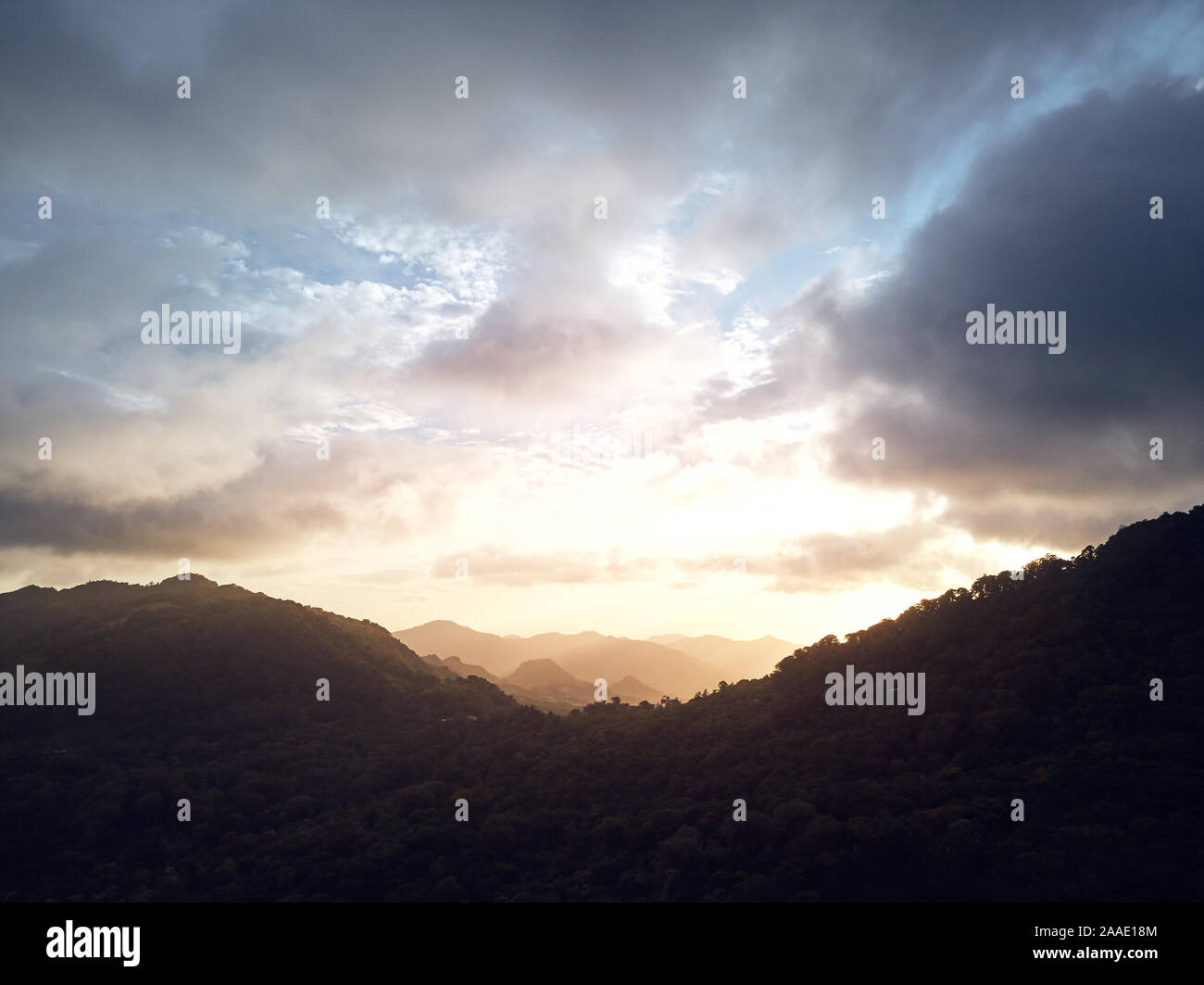 Dramatic sunset over mountain peaks aerial drone view Stock Photo