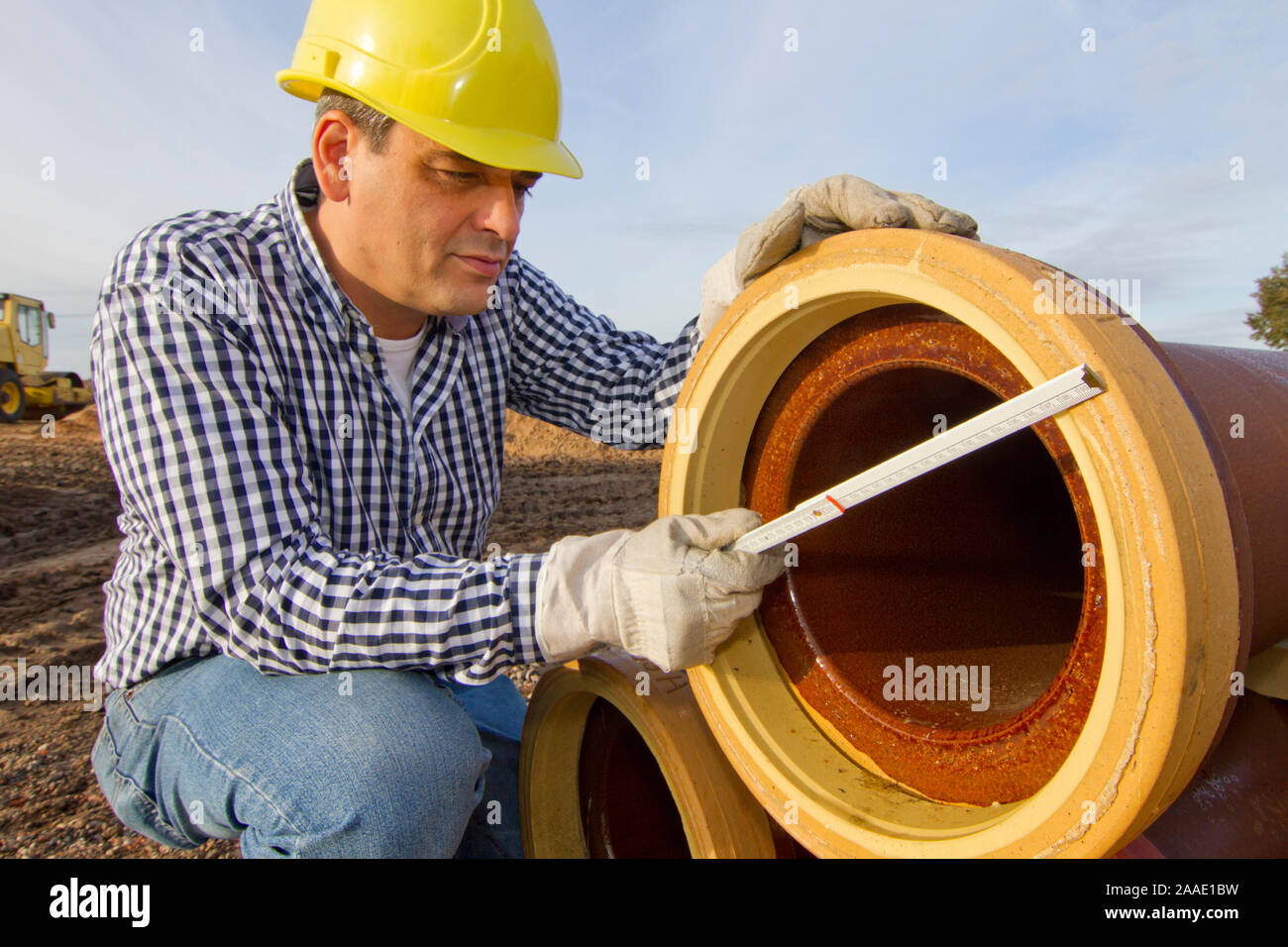 Bauarbeiter arbeitet mit Rohr Stock Photo