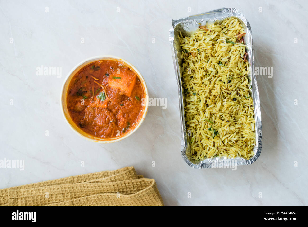 Take Away Indian Food Paneer Butter Tikka Masala / Cheese Cottage Curry and Jeera Zira Rice Basmati Pilaf or Pilav in Plastic Box Package / Container. Stock Photo