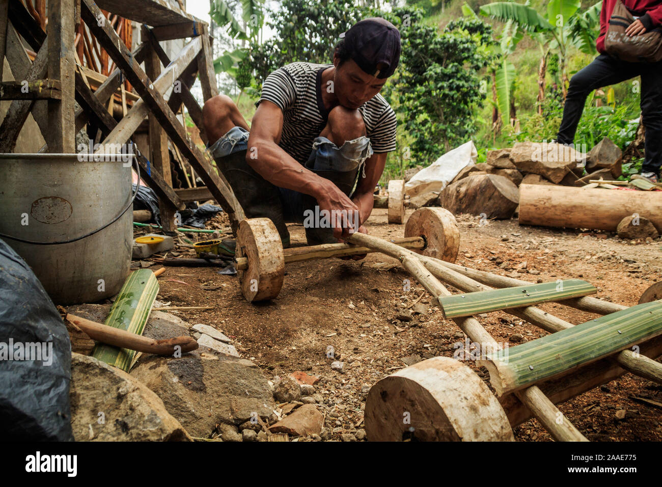 A resident fixes his bamboo car in Batu Lonceng Village, Lembang.The traditional game is a hereditary tradition held during the growing season holidays as well as entertainment to villagers. Stock Photo
