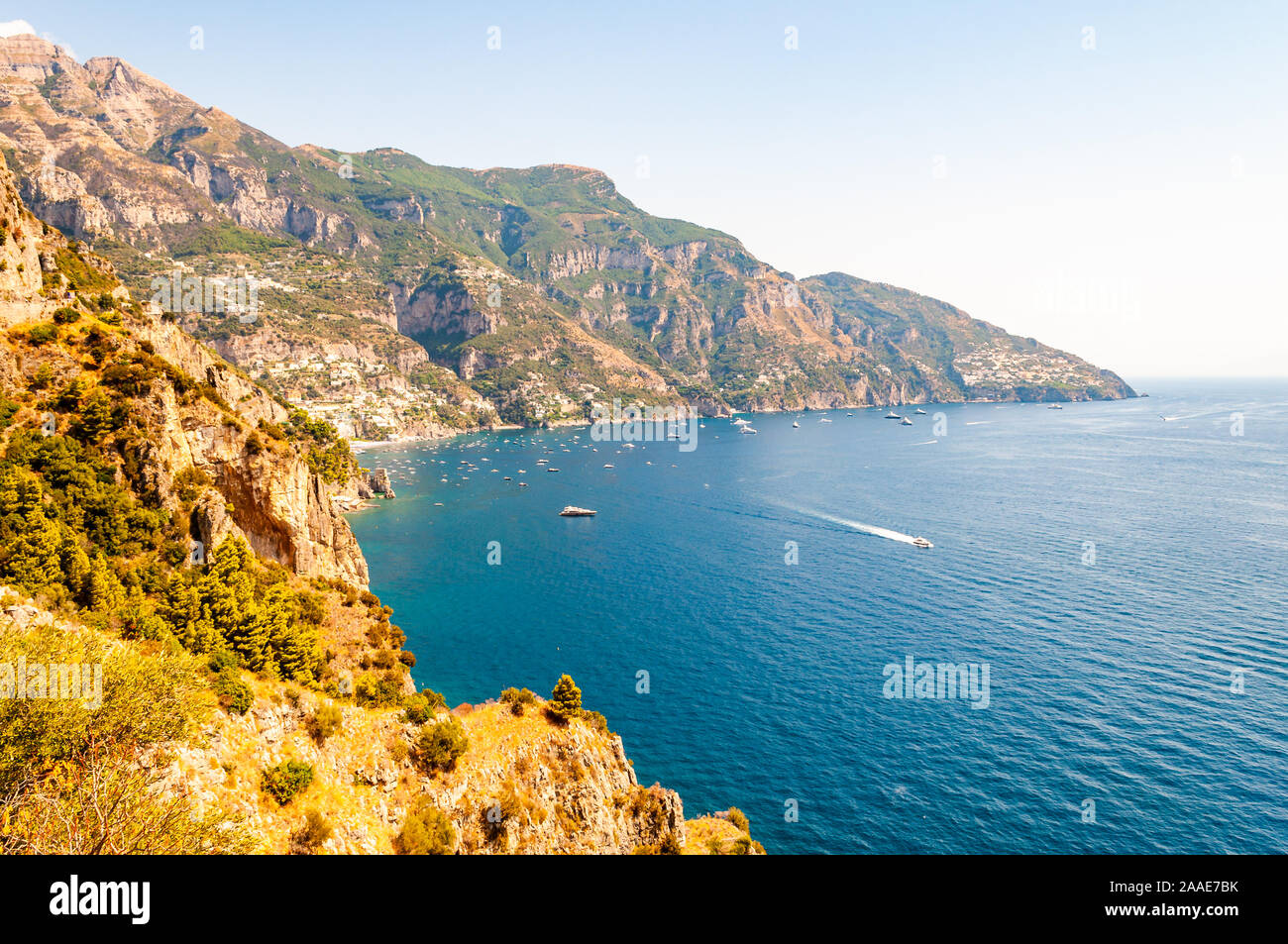 Beautiful scenic landscape of Positano, Italy. Rocky coastline full of boats and yachts traveling near high mountains. Cityscape of Positano surrounde Stock Photo