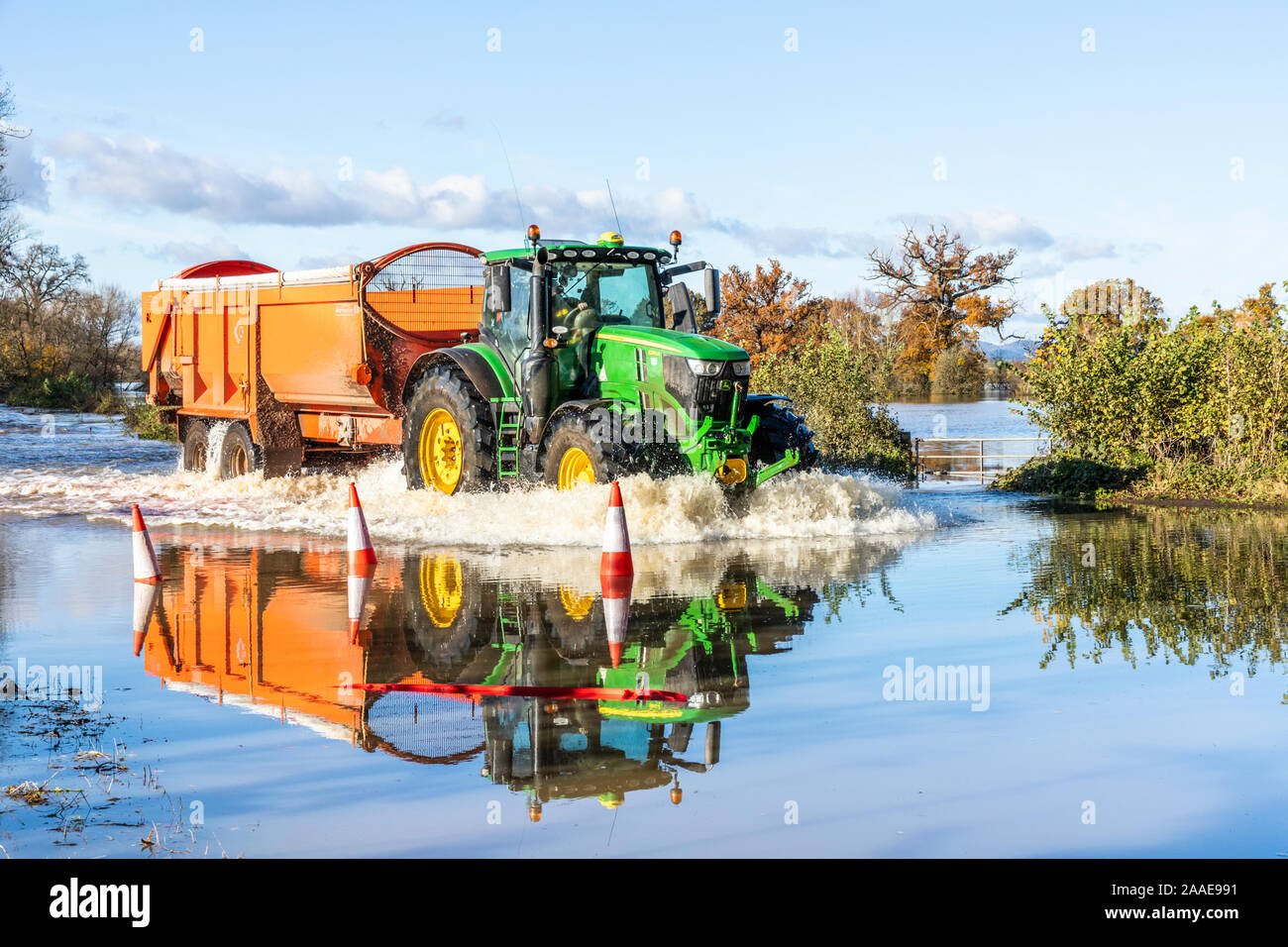 A tractor making its way through floodwater from the River Severn on the B4213 on the approach to Haw Bridge near the Severn Vale village of Apperley, Stock Photo