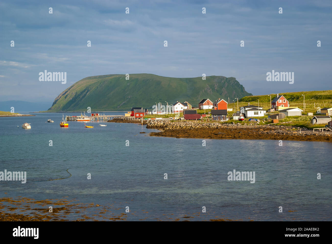Summer view of a small fishing village with traditional, colorful wooden houses in a quiet and calm bay of the Barents Sea above the arctic circle. Stock Photo