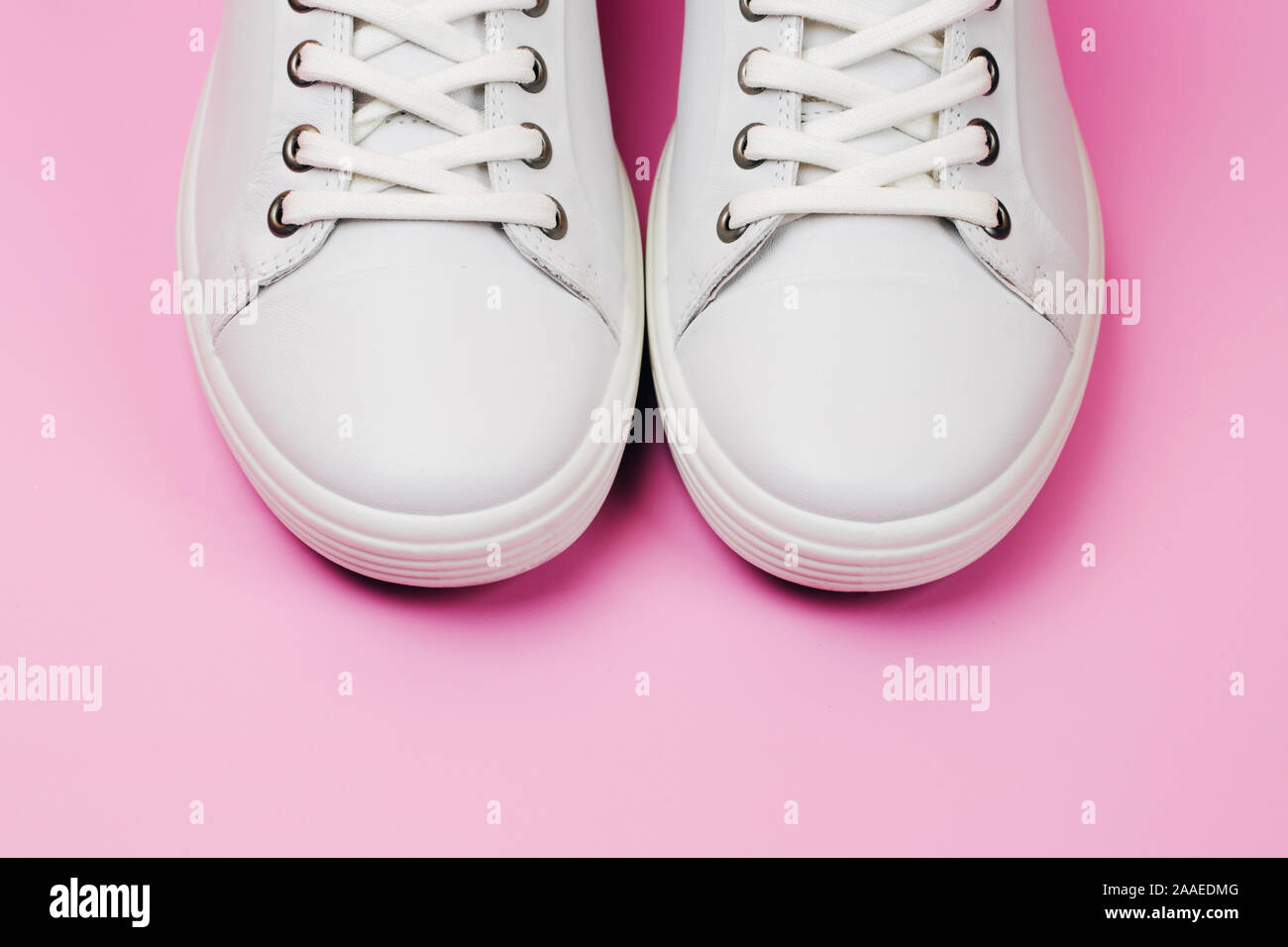 White trendy sneakers on pink pastel background. Front view. Minimal ...