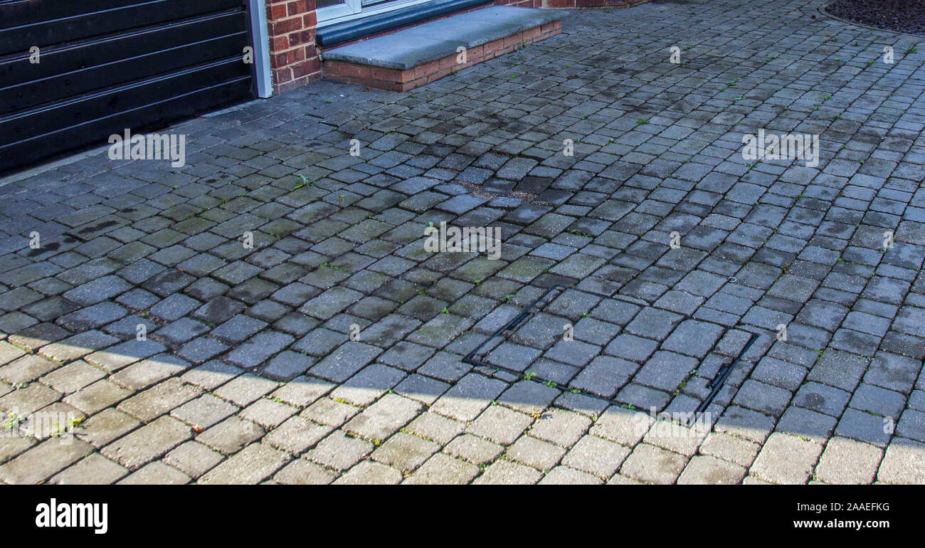 An old sunken block paved driveway in poor condition in Stockton on Tees,England,UK Stock Photo