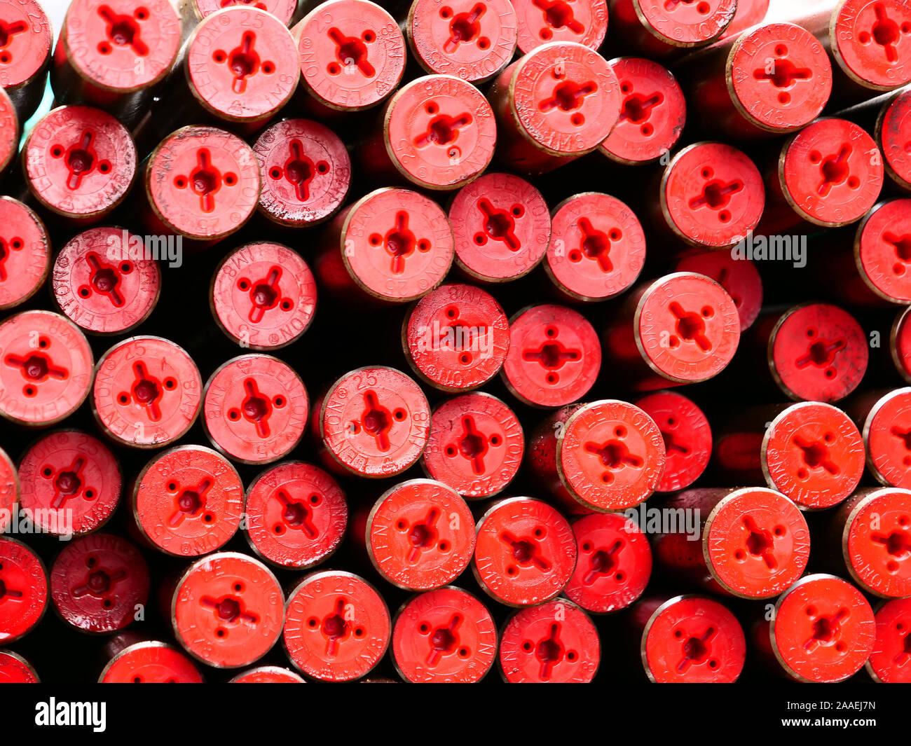 A large load of long and thin iron poles with red protection caps at both ends, have arrived on large lorry outside a construction site in London. Stock Photo