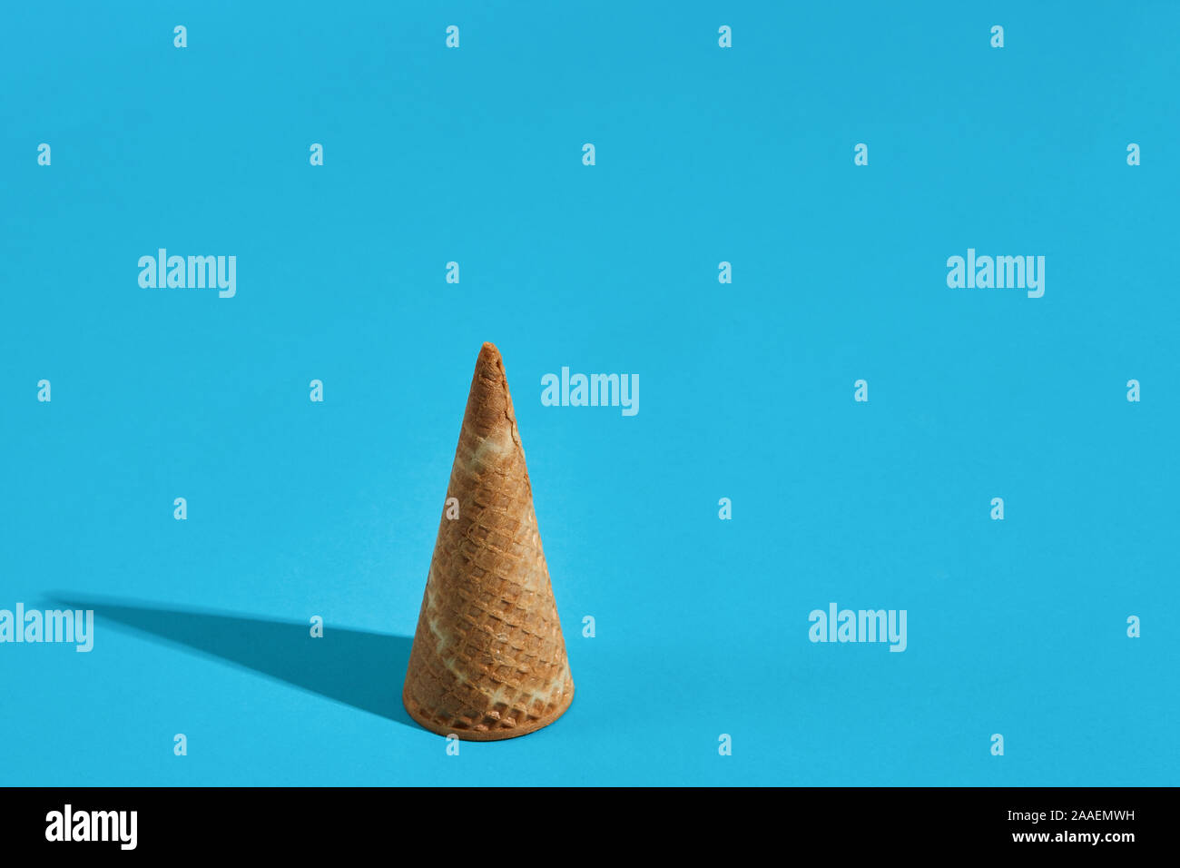 Waffle ice cream cones with shadow on a blue background Stock Photo - Alamy