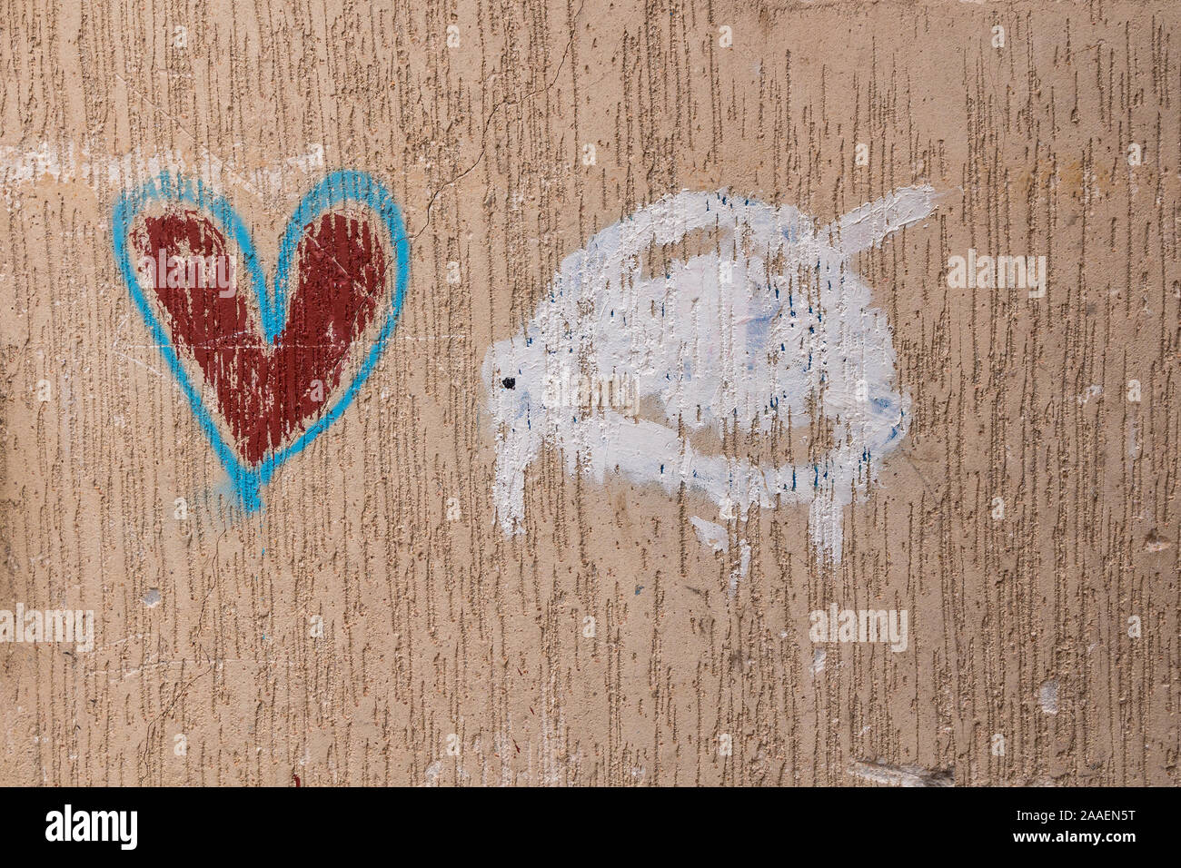 Non artistic small painting on a facade of a house: white turtle and heart with blue outline. Essaouira, Morocco. Stock Photo