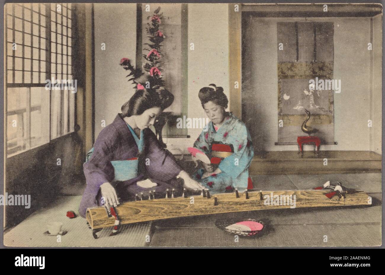 Illustrated postcard of two Japanese women wearing traditional kimono, kneeling on the floor playing the traditional Japanese stringed musical instrument called koto, Japan, 1920. From the New York Public Library. () Stock Photo