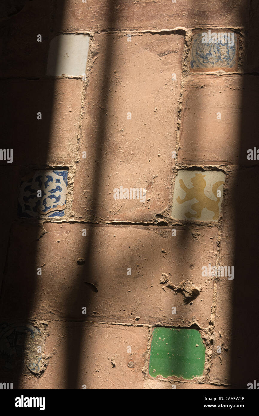 Decorative clay tiles embedded in clay bricks and the shadow of a barred window Stock Photo