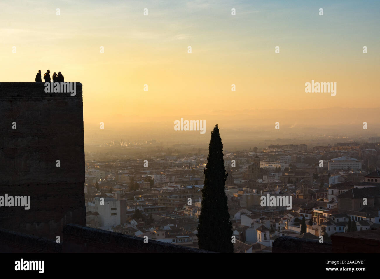 People gaze at the Spanish city of Granada from the Alcazaba fortress of the Alhambra palace during sunset Stock Photo