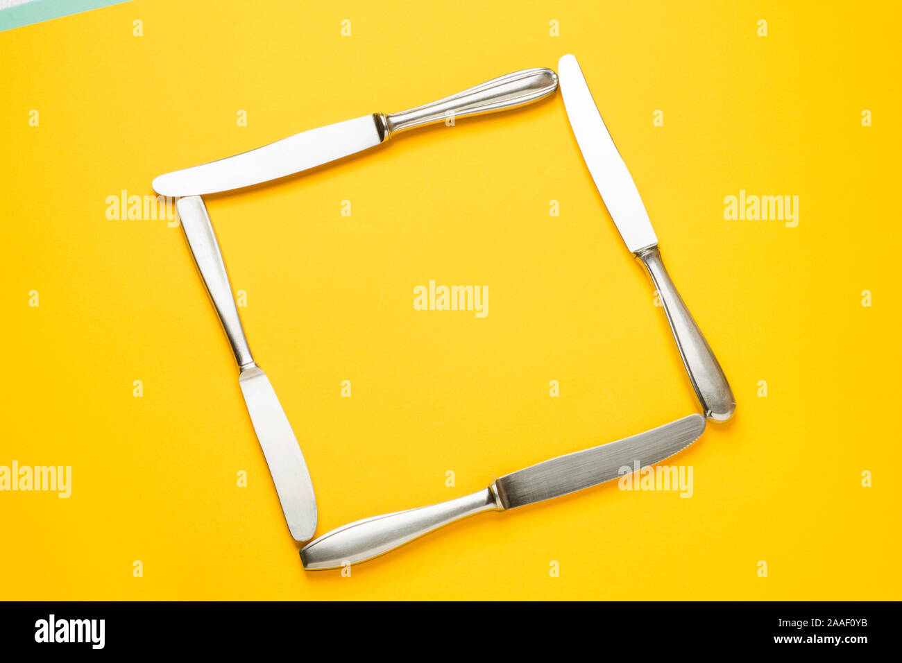Creative layout frame made of decorative set of knifes on a yellow background. Flat lay. Food concept. Lunch time. Stock Photo