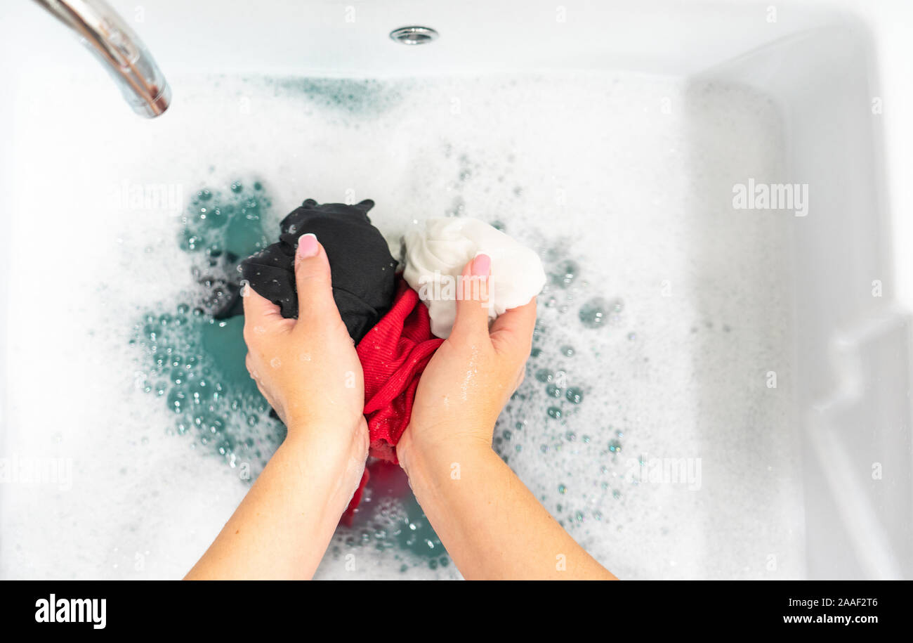 Laundry sink with handwashing different clored clothes Stock Photo