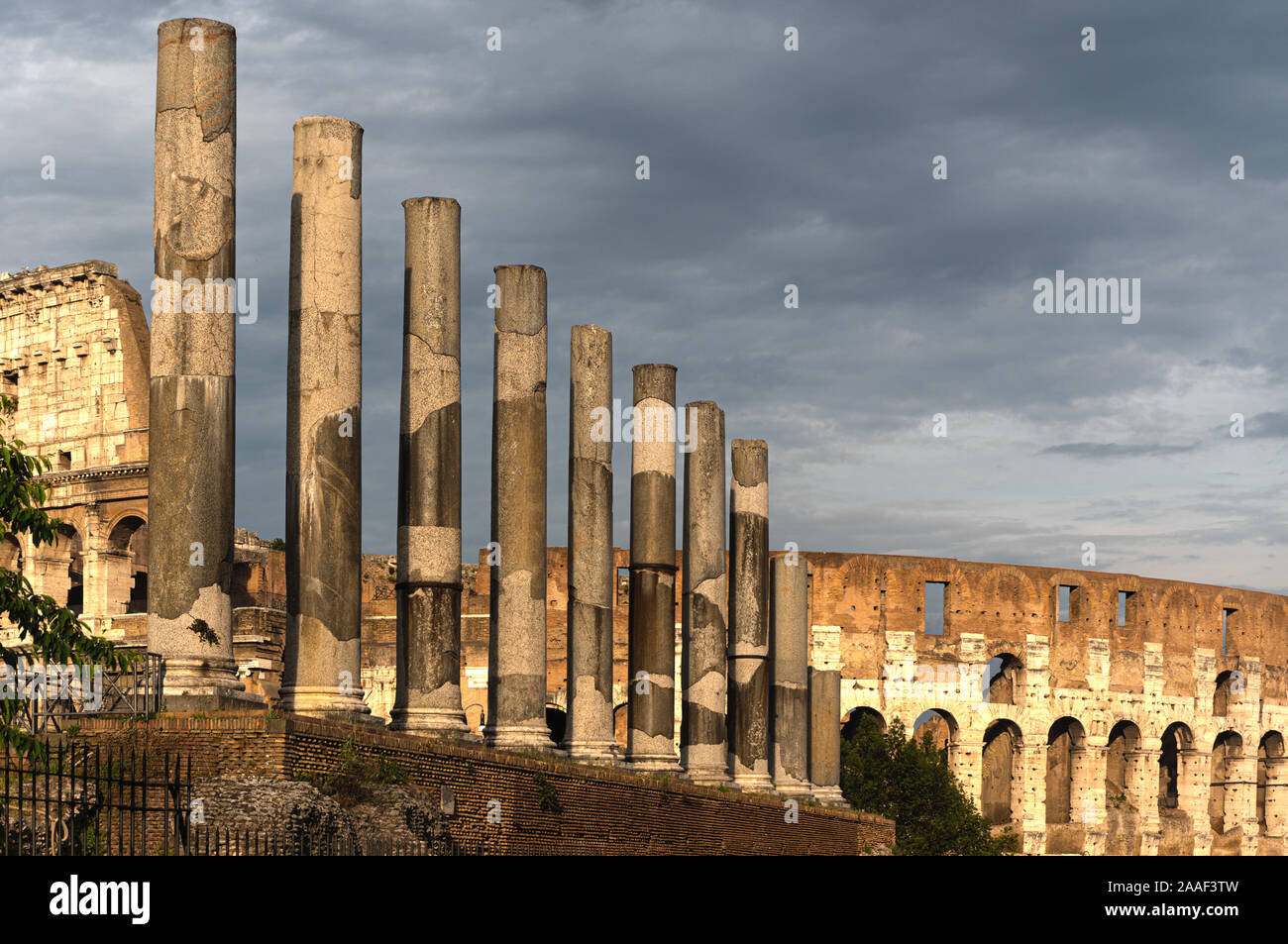 Columns of the Temple of Venus and Roma with the Colosseum, or Flavian Amphitheater, Rome, Italy Stock Photo
