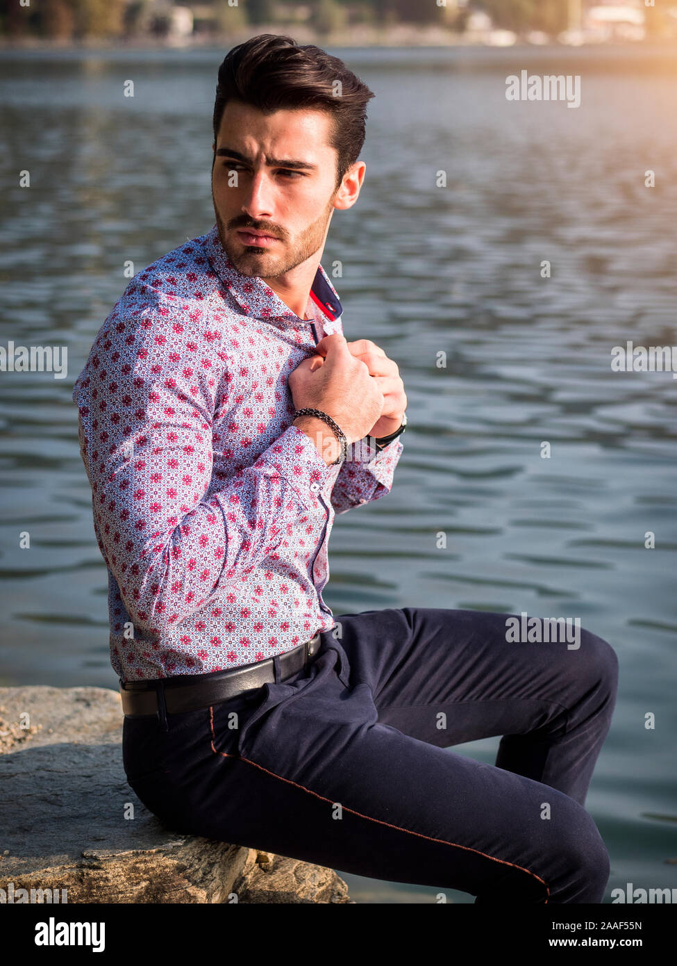 Young man wearing beside picturesque river or lake Stock Photo