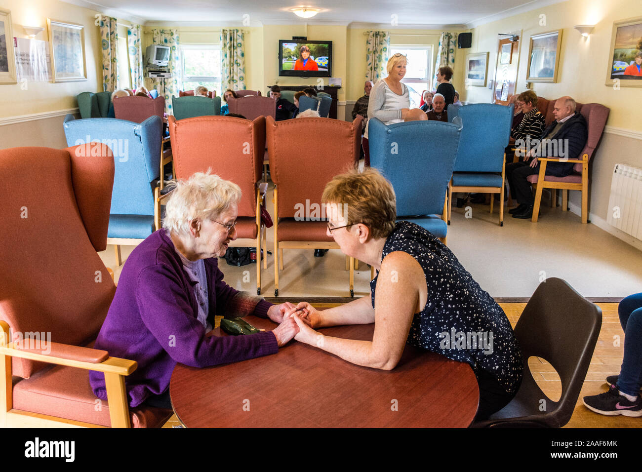 Glenties Day Care Centre, County Donegal, Ireland. A woman talks with a relative in the community centre. Many have dementia and Alzhemers here. Care in the community is important in rural Ireland. Many workers in this field are volunteers. Or work on a part time voluntary basis. Stock Photo