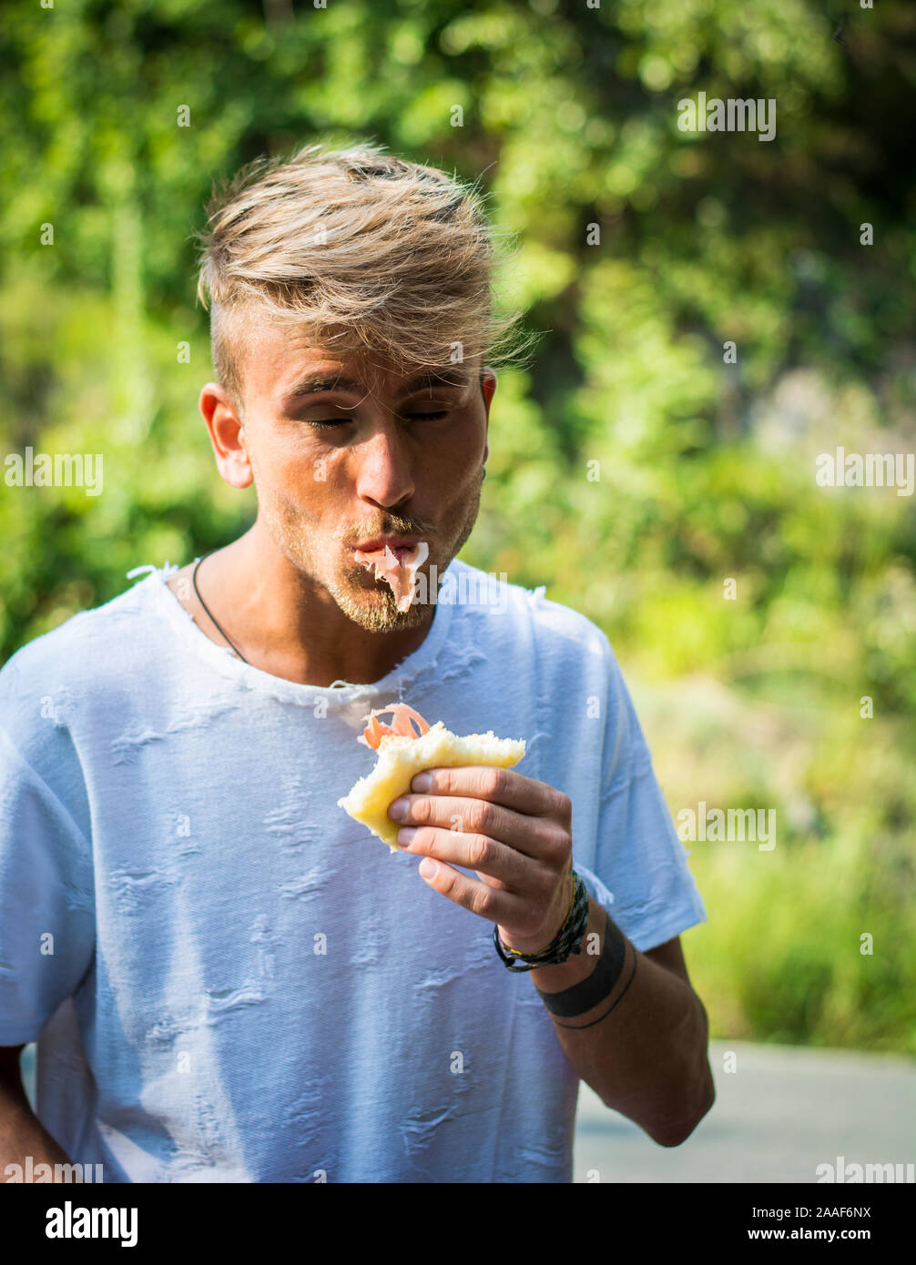 Man enjoying sandwich outside Stock Photo