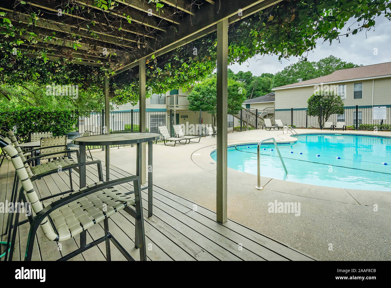The swimming pool features an outdoor seating area with a covered