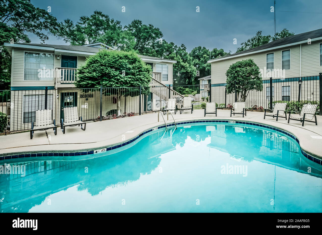 The swimming pool is shown with apartments in the background at