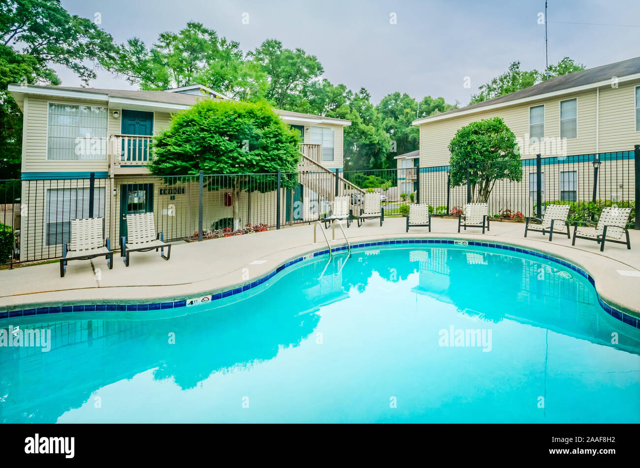 The swimming pool is shown with apartments in the background at
