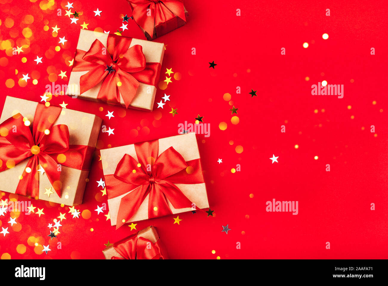 Several gift boxes with bows on a red background. Stock Photo