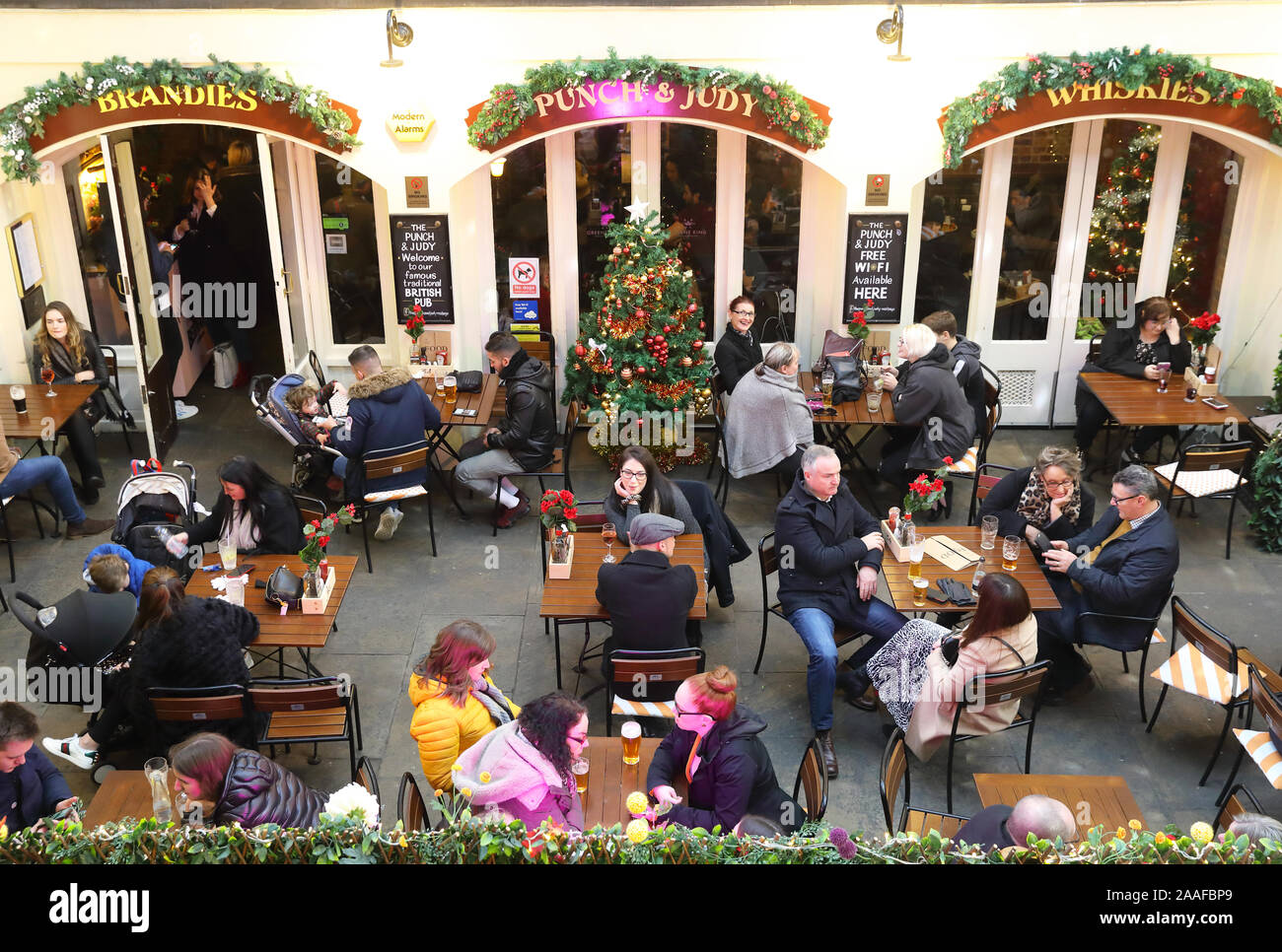 Sitting outside the Punch and Judy 18th century pub in Covent Garden, at Christmas time, in London, UK Stock Photo