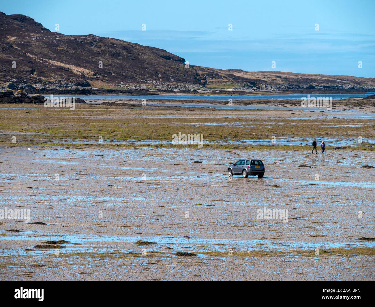 4x4 vehicle driving across The Strand at low tide from the Isle of Colonsay to the tidal island of Oronsay, Scotland, UK Stock Photo