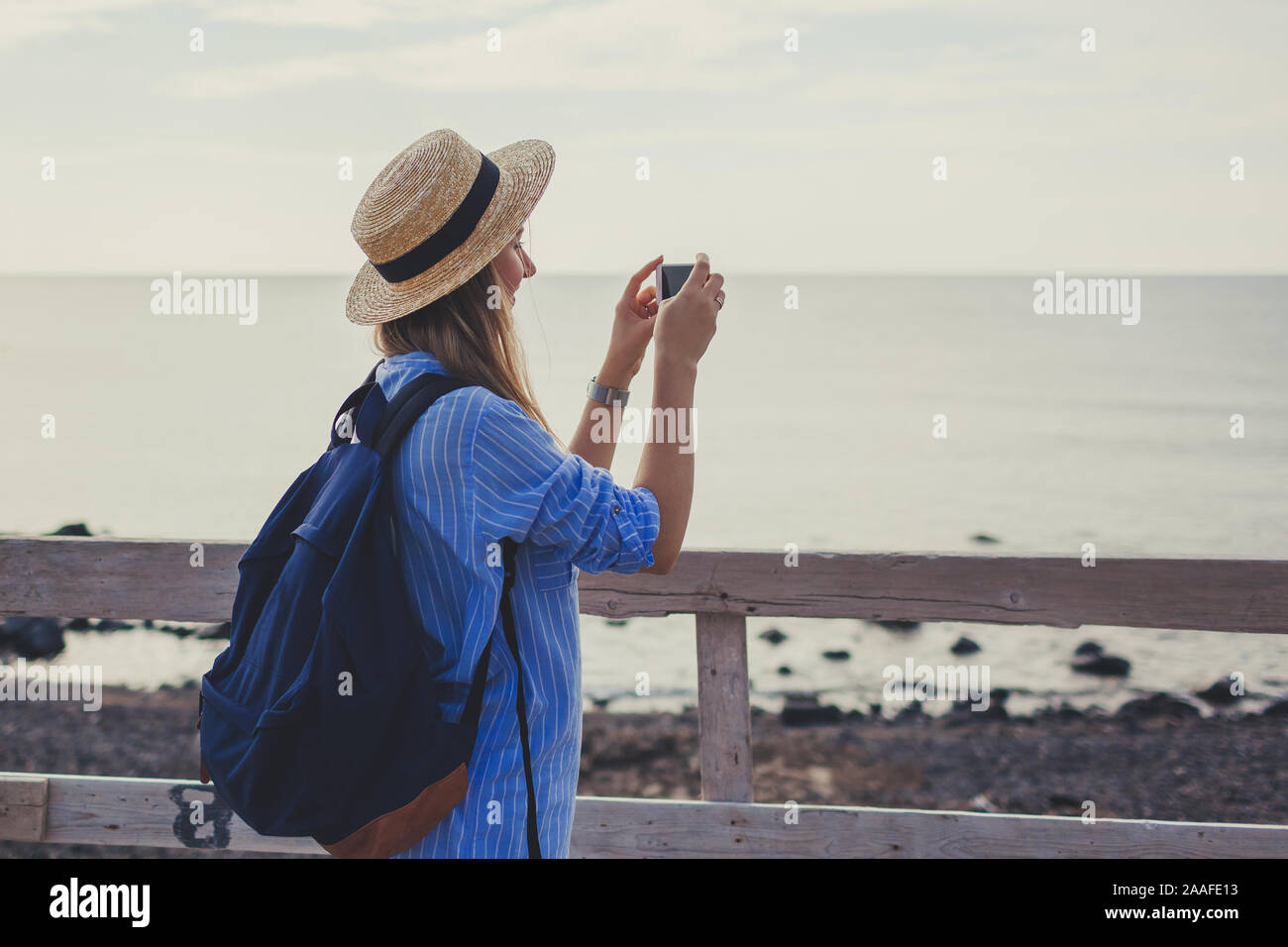 Woman traveler walking on Vlychada beach in Akrotiri on Santorini island, Greece. Tourist taking photo of sea Stock Photo