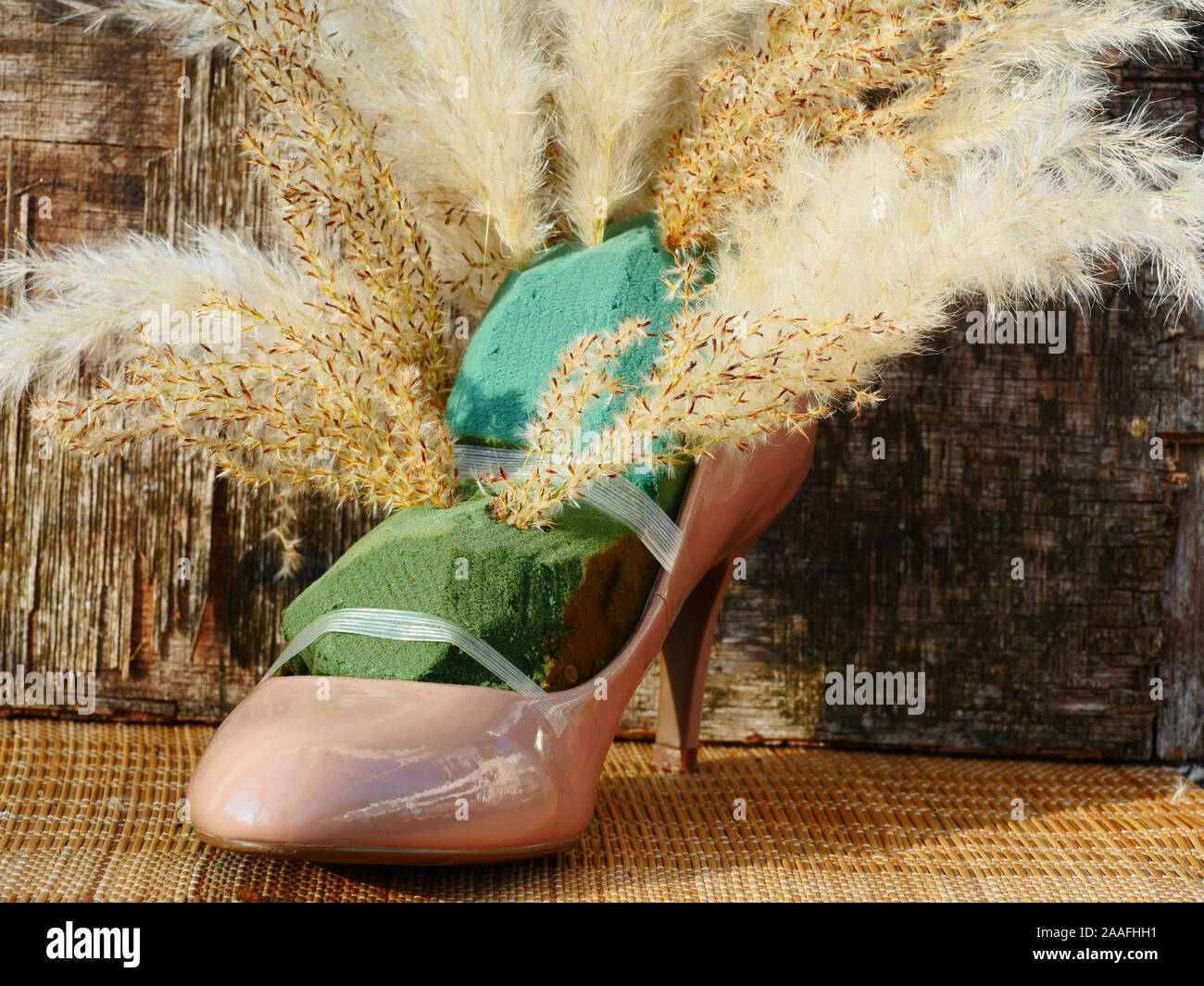 Dried Flower arrangement in a shoe starting to arrange the grass in the