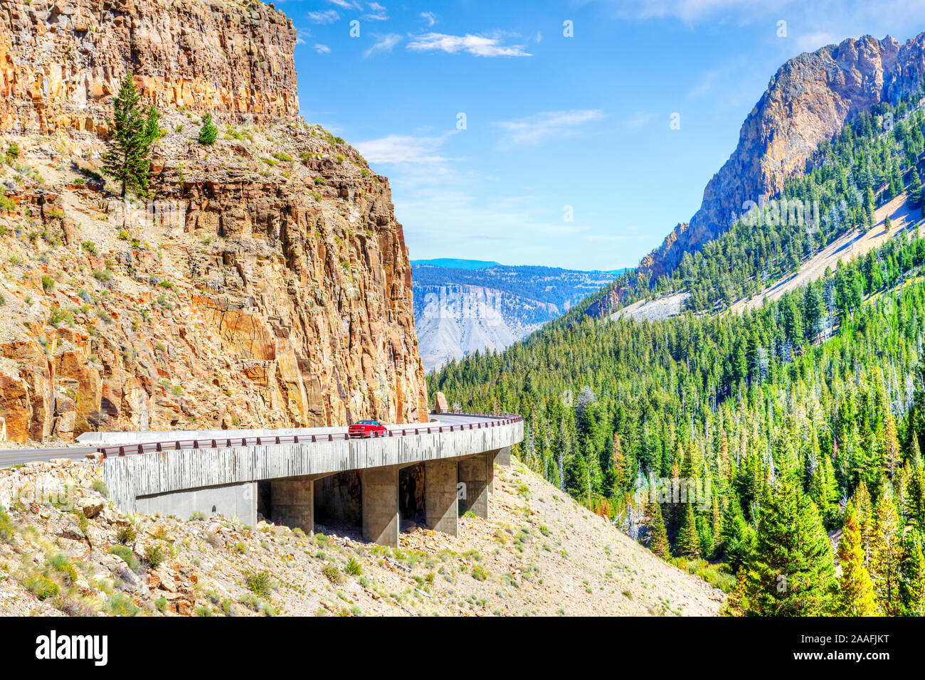 Red car on Grand Loop Road through Golden Gate Canyon at Kingman Pass in the northwestern region of Yellowstone National Park, Wyoming, USA. Stock Photo