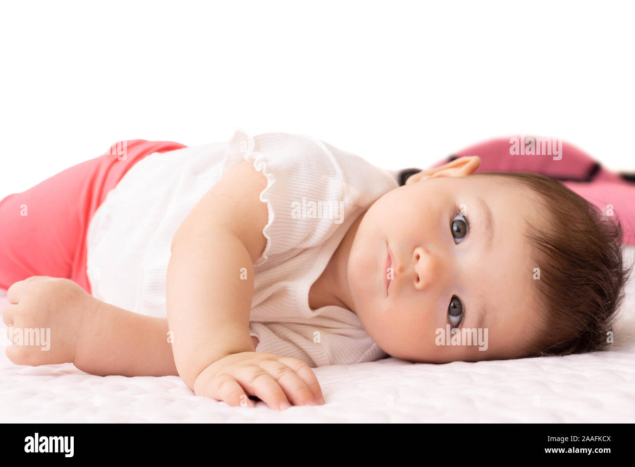 baby lying on the bed side way. clean baby face and closeup eyes Stock