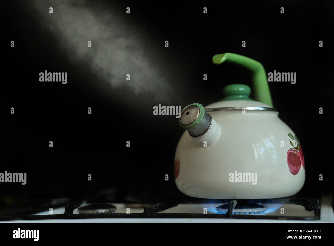 the kettle with hot boiling water and the steam comes out from it on