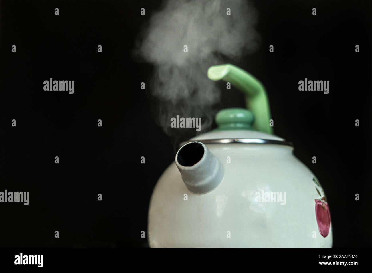 the kettle with hot boiling water and the steam comes out from it on