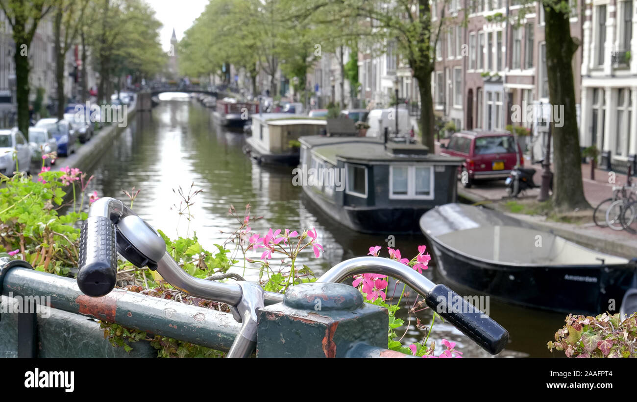 bicycle handle bars and a shallow depth of field shot of a canal in amsterdam Stock Photo