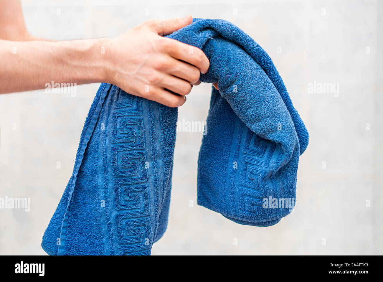 person hand holding a color towel before taking a bath Stock Photo Alamy