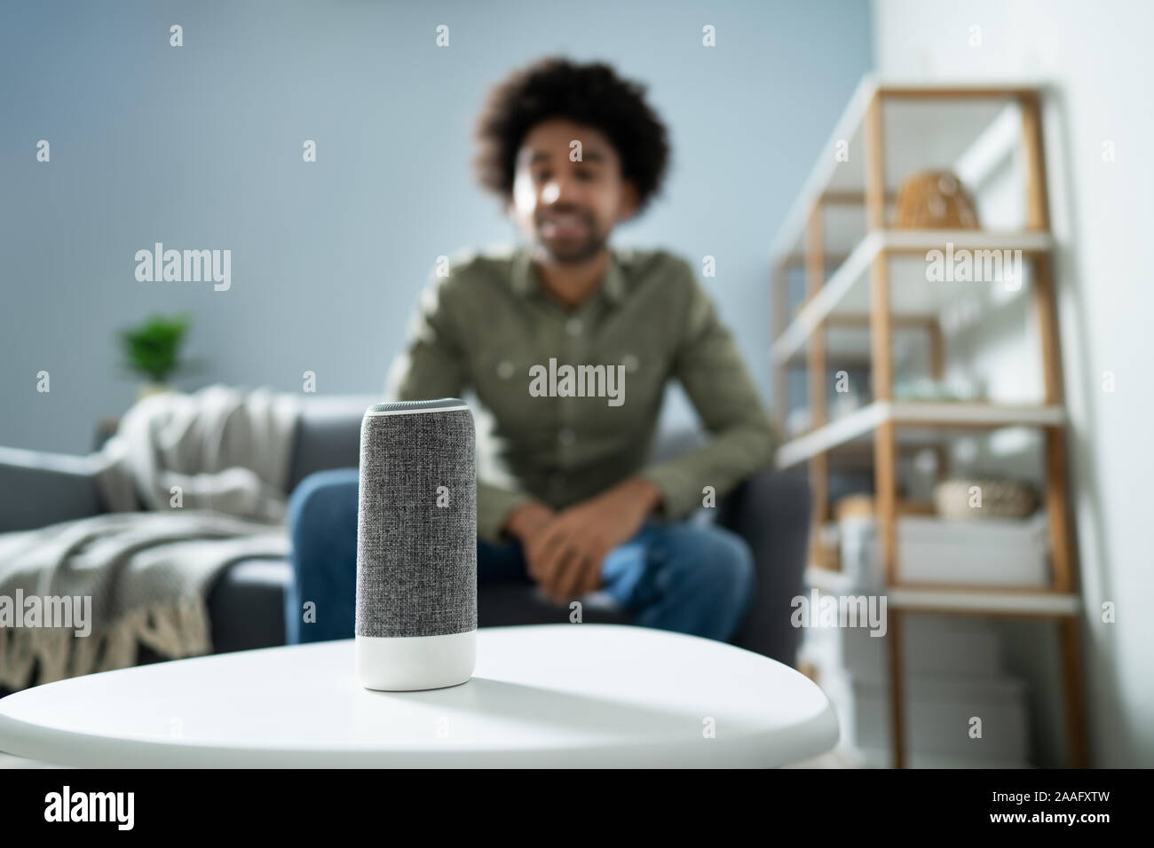 Young Man Using Wireless Speaker At Home Stock Photo