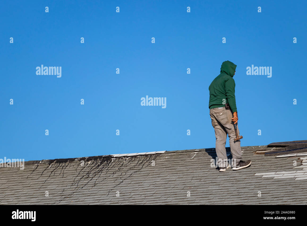 Montauk, NY: Construction workers at work on a rooftop shingle repair job Stock Photo