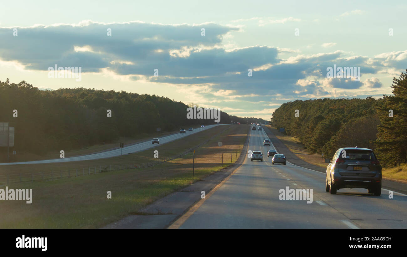 Long Island, NY - Wide scenic view of cars travelling along the Southern State Parkway in late autumn Stock Photo
